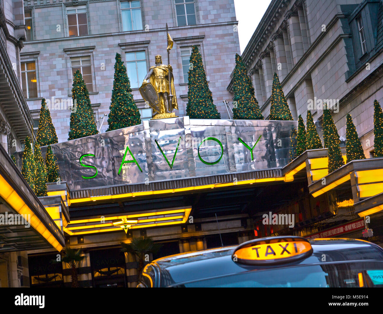 SAVOY HOTEL LONDON TAXI Außenansicht des luxuriösen Fünf-Sterne-Hotel Savoy Eingang an Weihnachten mit London Taxi mieten im Vordergrund The Strand London Stockfoto