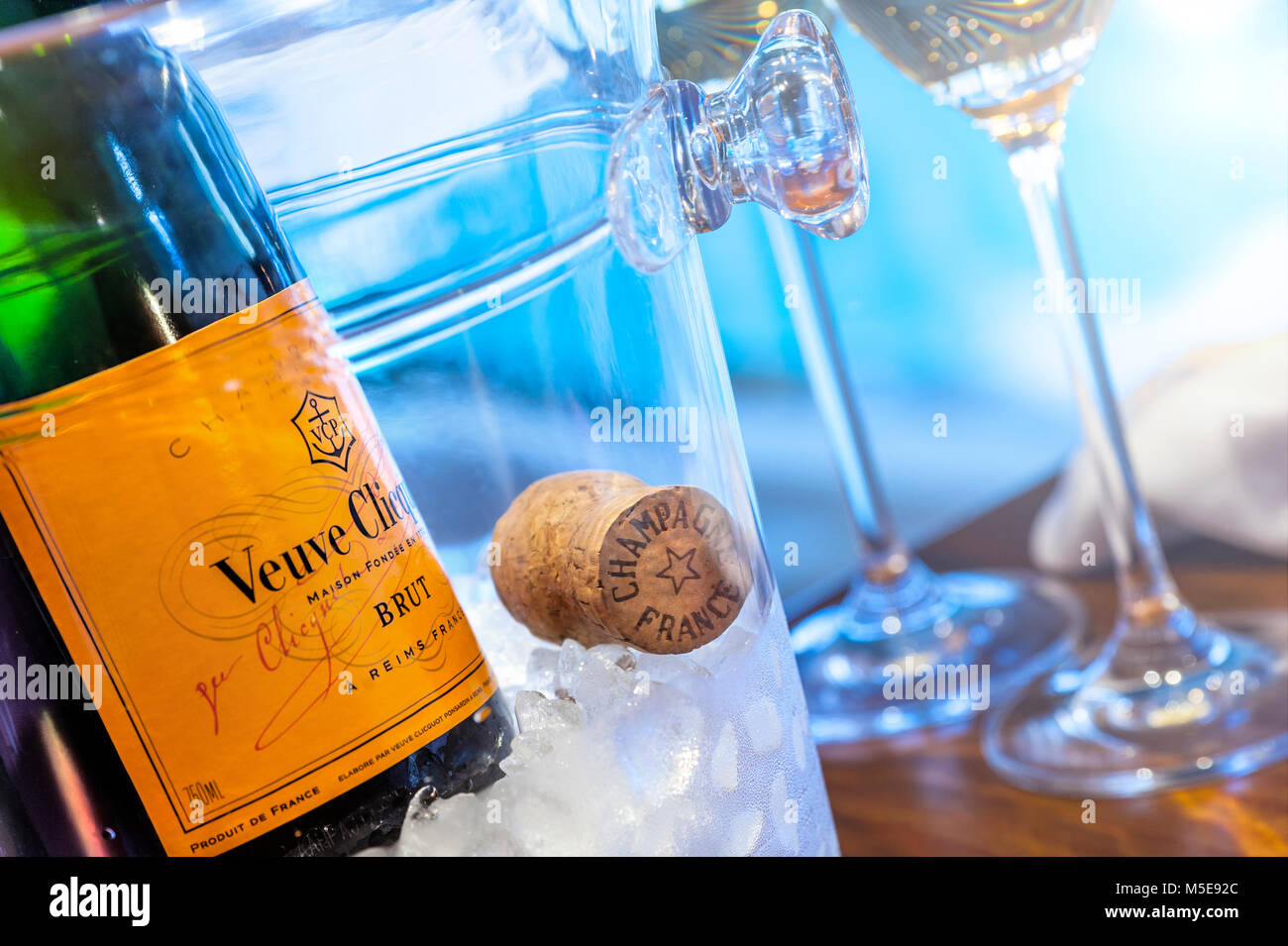 Veuve Clicquot feine Champagner-Flasche auf Eis mit Kork und Gläsern, Luxus-Ambiente, Pool im Hintergrund mit Sonnenuntergang am späten Nachmittag Stockfoto