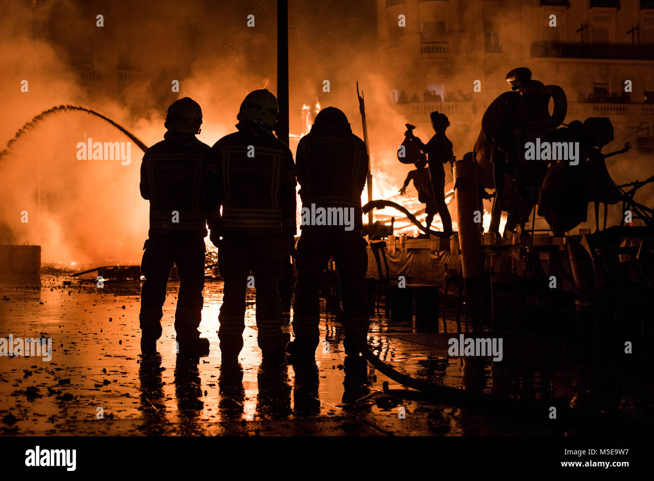 Feuerwehrmänner bei der Arbeit während der Nacht von "La Crema" die Verbrennung an der valenzianischen Rathausplatz als Teil des letzten Tages Las Fallas Festivals in Sp Stockfoto