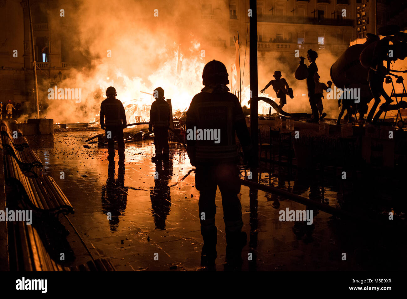 Feuerwehrmänner bei der Arbeit während der Nacht von "La Crema" die Verbrennung an der valenzianischen Rathausplatz als Teil des letzten Tages Las Fallas Festivals in Sp Stockfoto