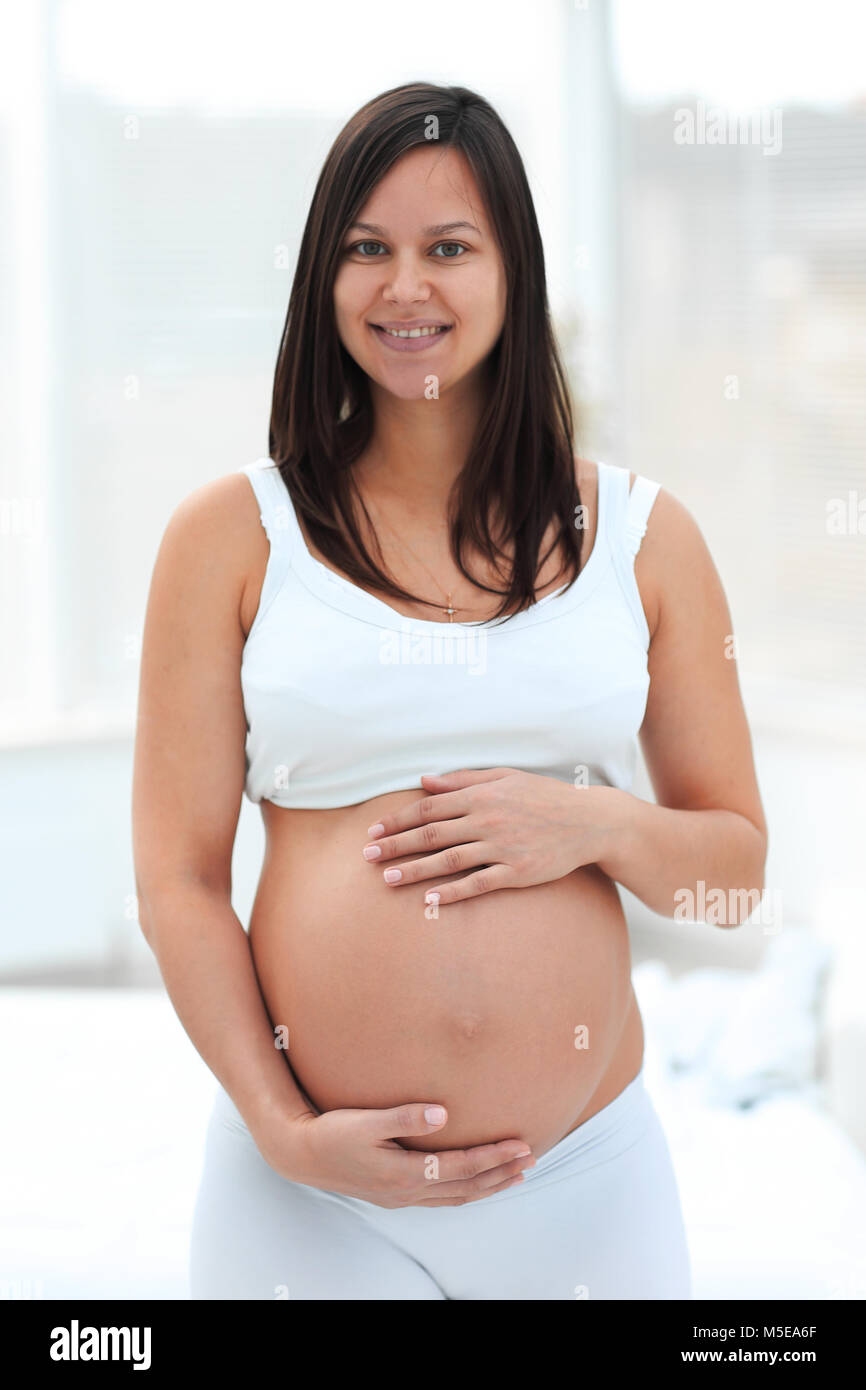 Portrait von jungen schwangeren Frau auf einem hellen Hintergrund. Stockfoto
