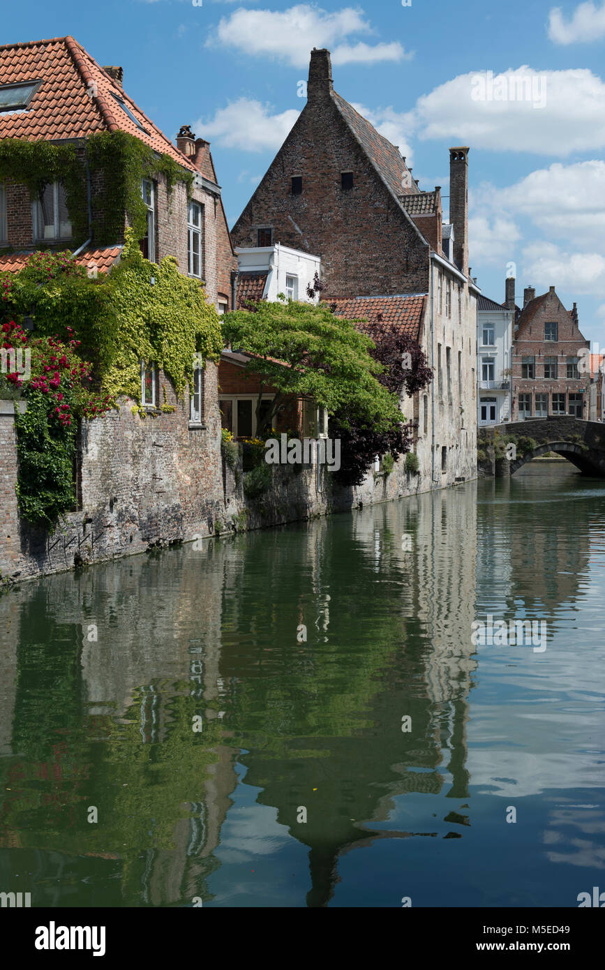 Alte Gebäude und deren Reflexionen in der Gouden-Handrei Canal, Brügge, Belgien. Stockfoto