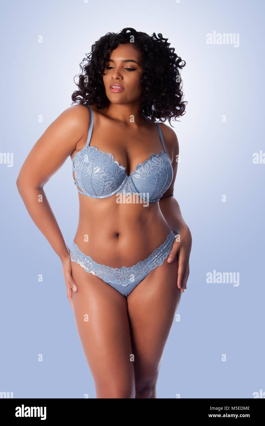 Schöne happy Plus size sexy Frau mit lockigem Haar in Hellblau dessous BH  und Tanga Unterwäsche Stockfotografie - Alamy