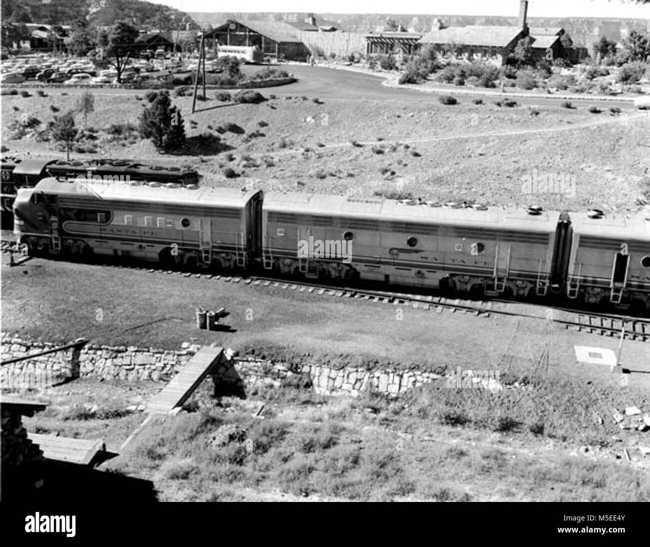 B Grand Canyon historischen Railroad Depot auf der Suche N UND SEITLICH AUF DER DIESELLOK AUF DER LÄNGSTEN ZUG ZUM EINGEGEBENEN GRAND CANYON HABEN, DIE ELCHE, entnommen aus dem Kraftpaket. BRIGHT ANGEL LODGE DARÜBER HINAUS. 05. JULI 1956. Stockfoto