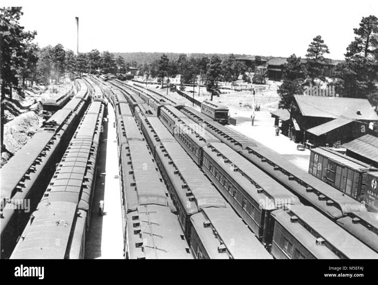 Grand Canyon historischen Railroad Depot - Züge nach Westen bei 5 PERSONENZÜGE FÜLLUNG GRCA HOF. DEPOT (R) & GÜTERWAGEN. CIRCA 1926. SANTA FE RR. Stockfoto