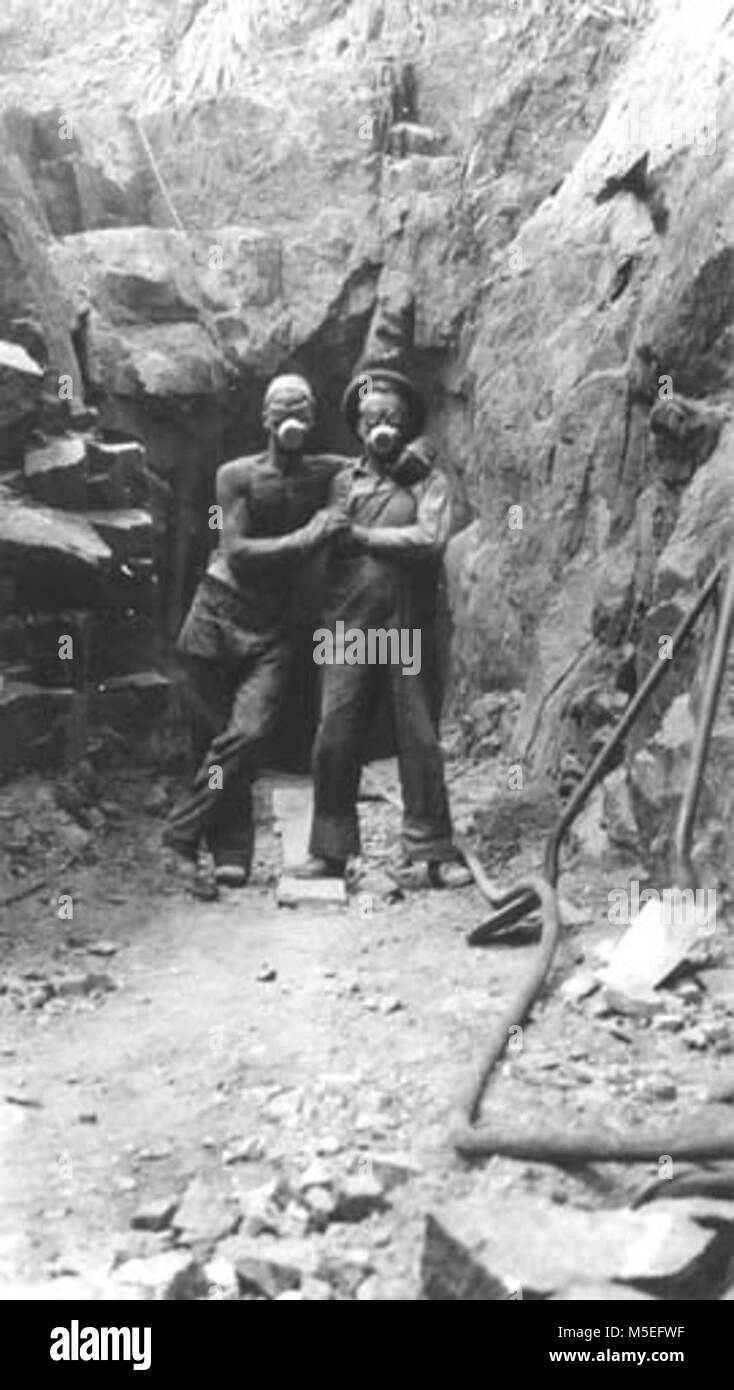 Grand Canyon Historischen - Kaibab Suspension Bridge Arbeitnehmer c 1928 KAIBAB BRÜCKENBAU. Arbeitnehmer stehen zusammen und das Tragen von Atemschutzmasken. TUNNEL HINTER IHNEN. GC 28 L 27. 1928. Stockfoto