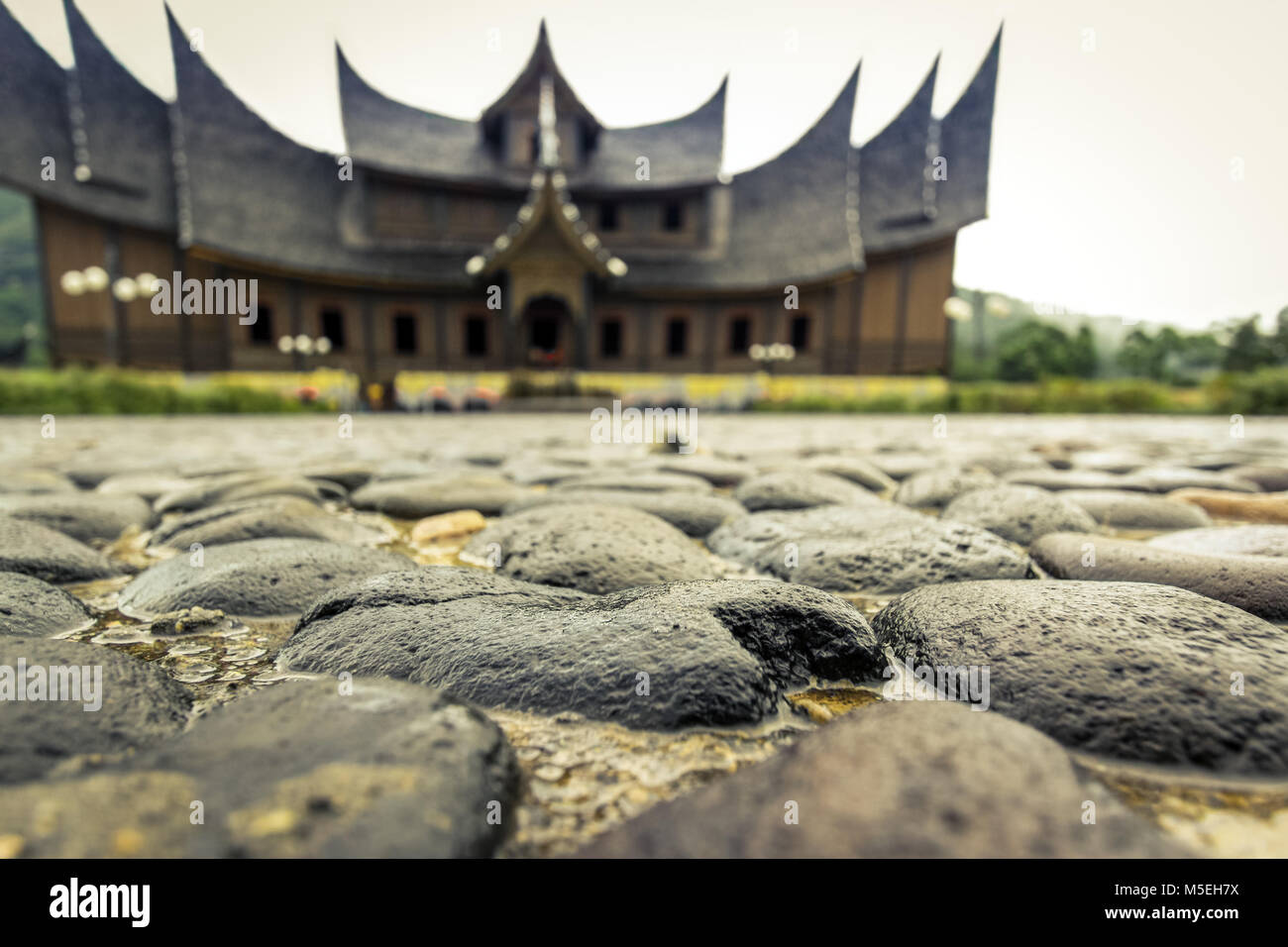 Historische Minangkabau Gebäude. Pagaruyung Palace Royal Residence. Jetzt eine touristische Attraktion. Extreme Low Angle View mit einzigartigen gepflasterten Gehweg. Stockfoto