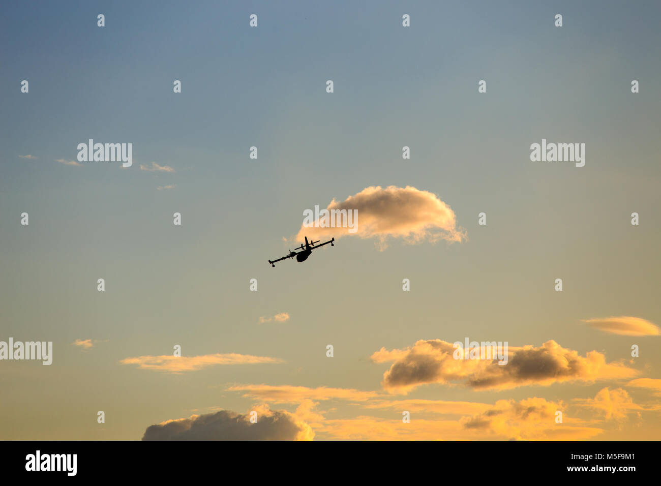 Flugzeuge silhouette Flyes am Himmel durch die Wolken bei Sonnenuntergang Stockfoto
