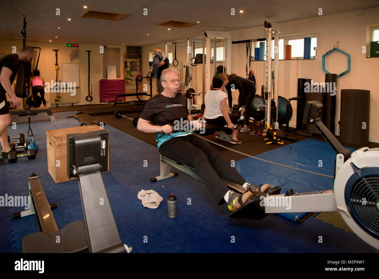 Ältere männliche arbeitet sie im Fitnessraum, fit halten, aber erschöpft, Epsom, Großbritannien Stockfoto