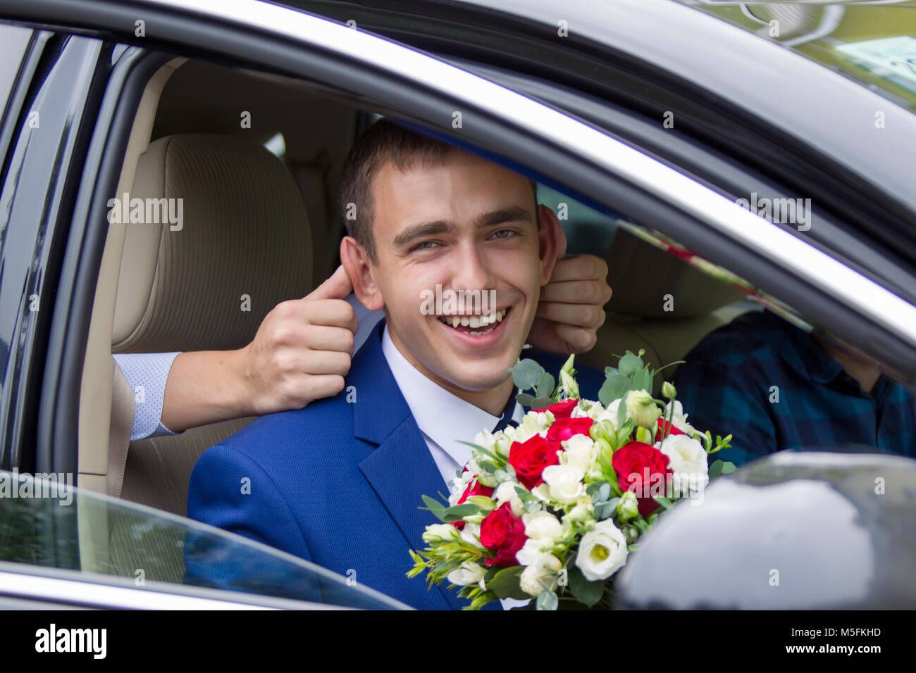 Belarus, die Stadt Gomel. Am 15. Juli 2017. Zentrale Hochzeit Haus. Freundliche Bräutigam sitzen im Auto fröhlich lachend. Merry Bräutigam. Der Bräutigam wird Stockfoto