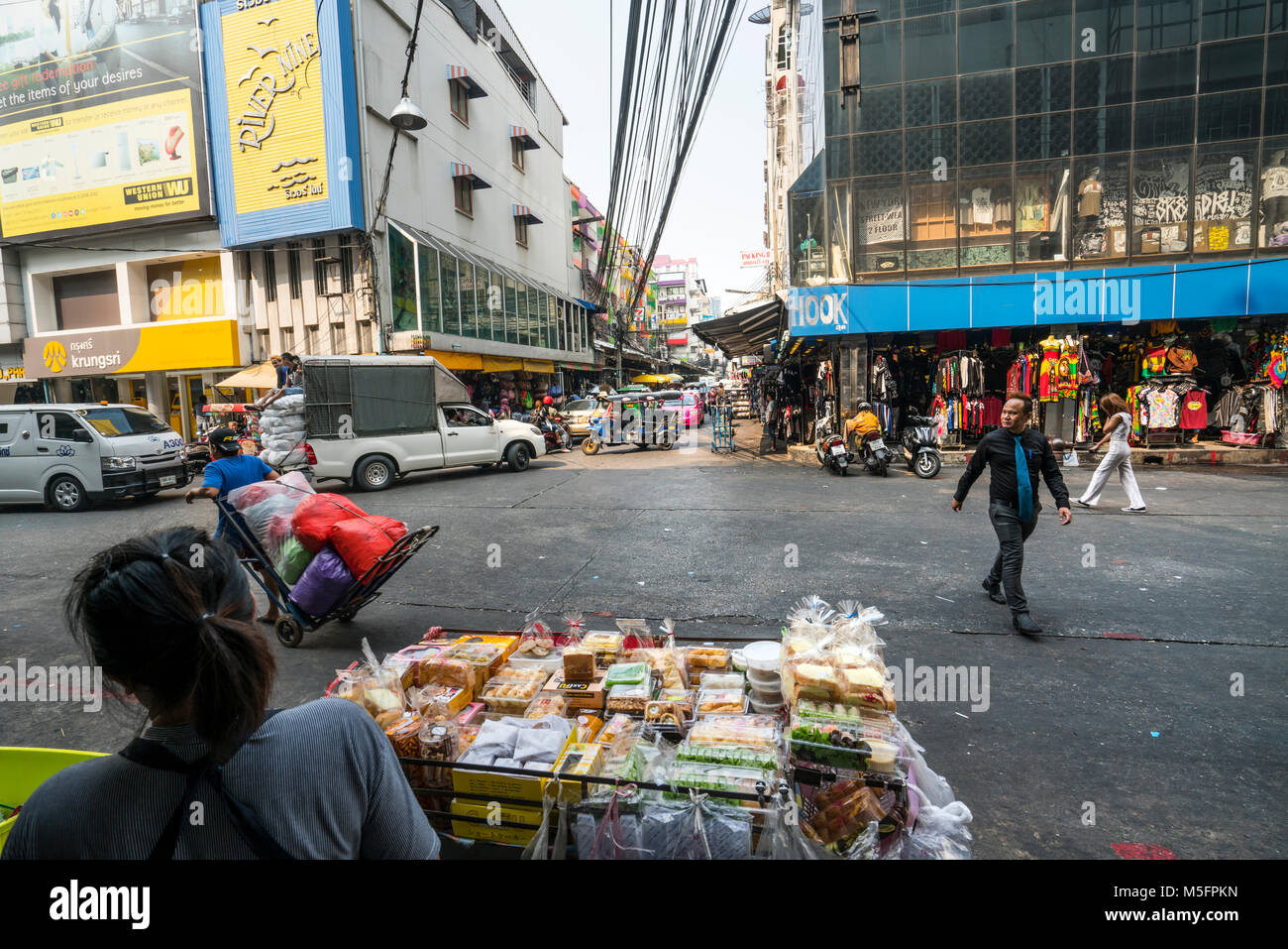 Eine Frau, die durch den Verkauf von Waren in einem kleinen Stall auf einem Bangkok street Stockfoto