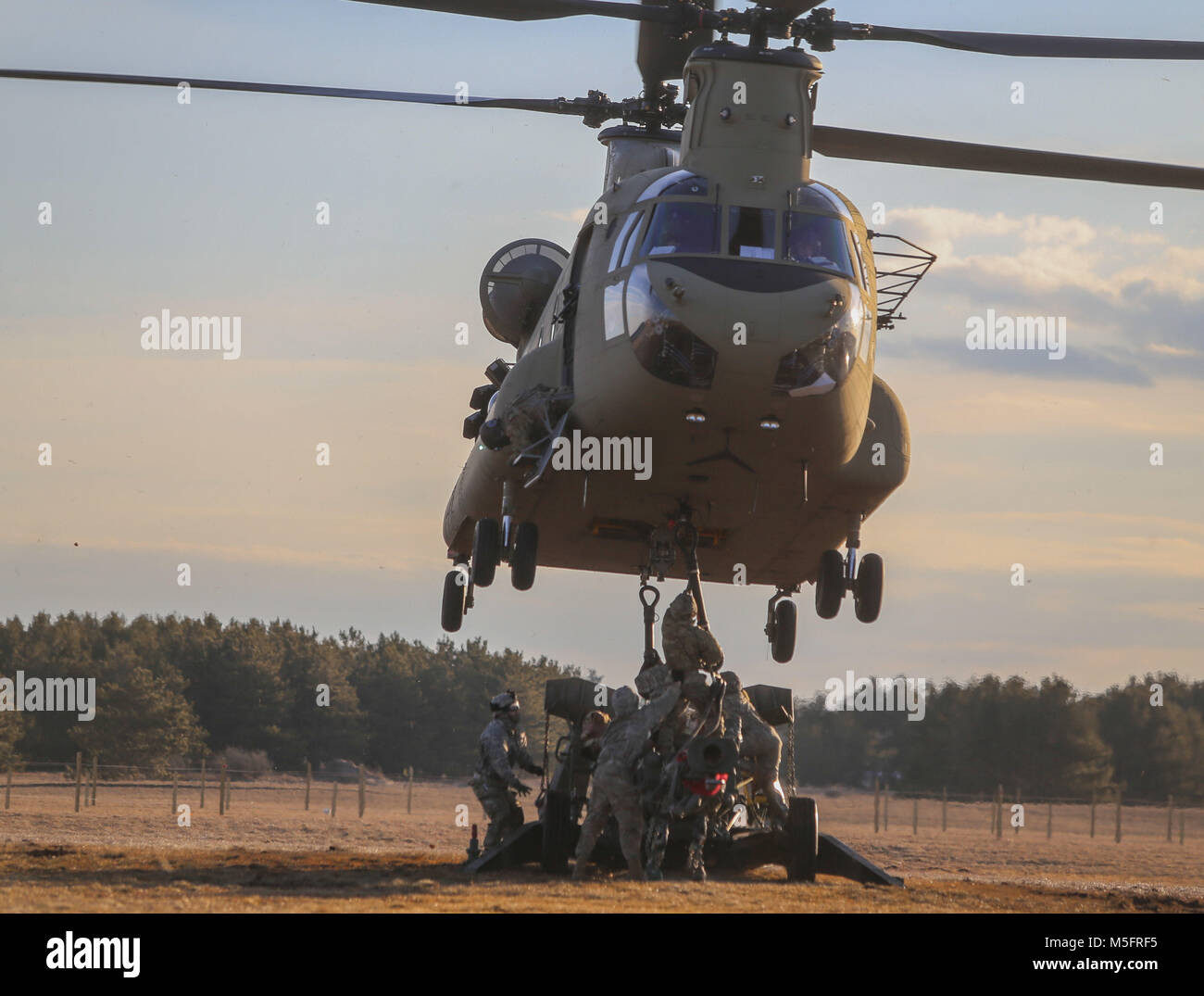 Soldaten des 3.BATAILLON zugeordnet, 6 Field Artillery Regiment, 1st Brigade Combat Team, 10 Mountain Division (LI), Sling laden Sie ein M777A2 Howitzer zum Ende einer CH-47 Chinook an Abteilung Hill, Fort Drum, New York, während einer Air Assault Übung, 21. Februar 2018. Stockfoto