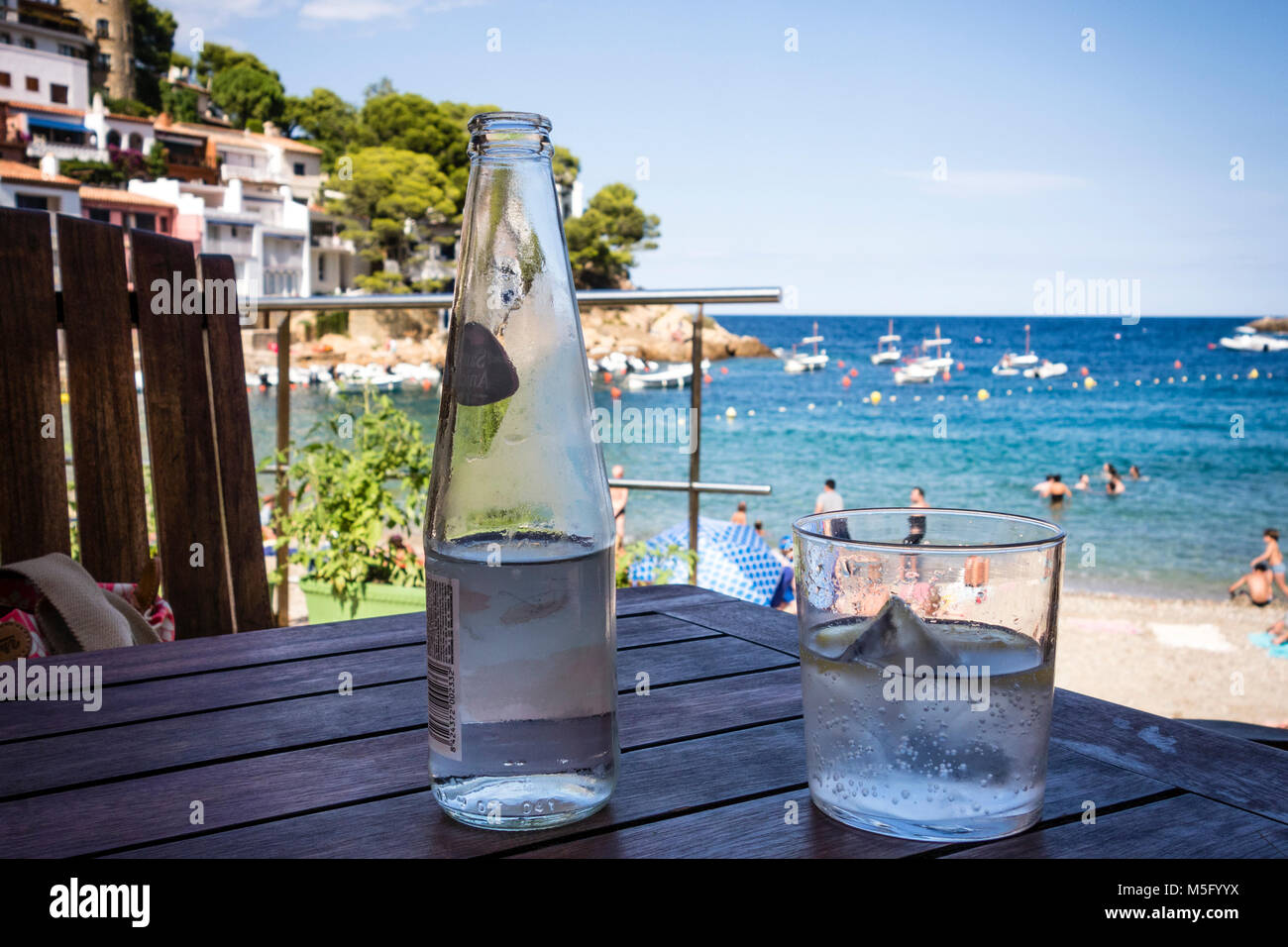 Gekühltes Wasser Flasche und Glas auf dem Tisch, Bucht von Sa Tuna, Begur, Baix d'Emporda, Costa Brava, Katalonien, Spanien Stockfoto
