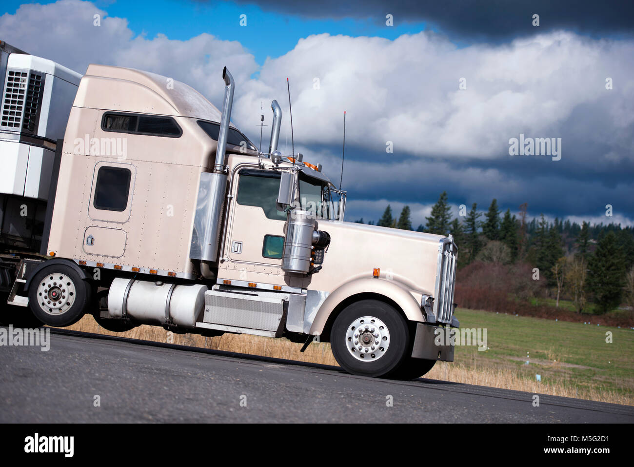 Leistungsstarke beige Big Rig classic leistungsfähige Semi Truck mit Chrom Zubehör und hohen auspuffrohre Cargo Transport im Kühlschrank Auflieger auf t Stockfoto
