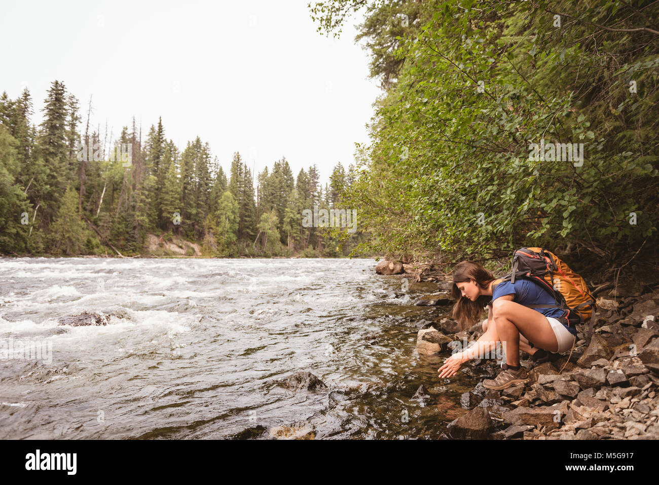 Frau waschen ihre Hand in den Fluss Stockfoto