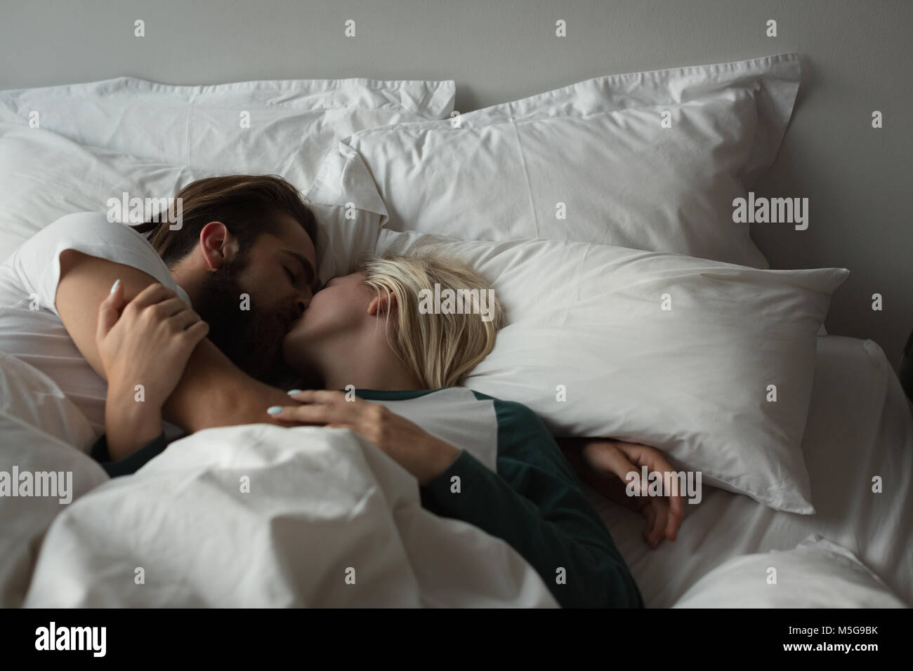 Romantic Couple Kissing In Bed Stockfotos Romantic Couple