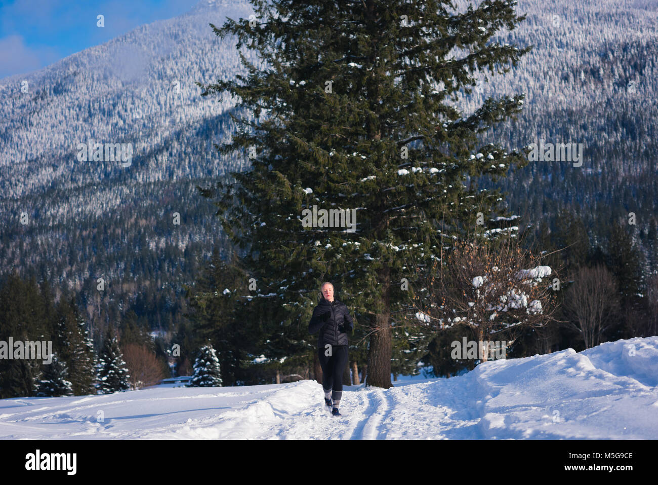 Athletische Frau joggen auf verschneite Landschaft Stockfoto