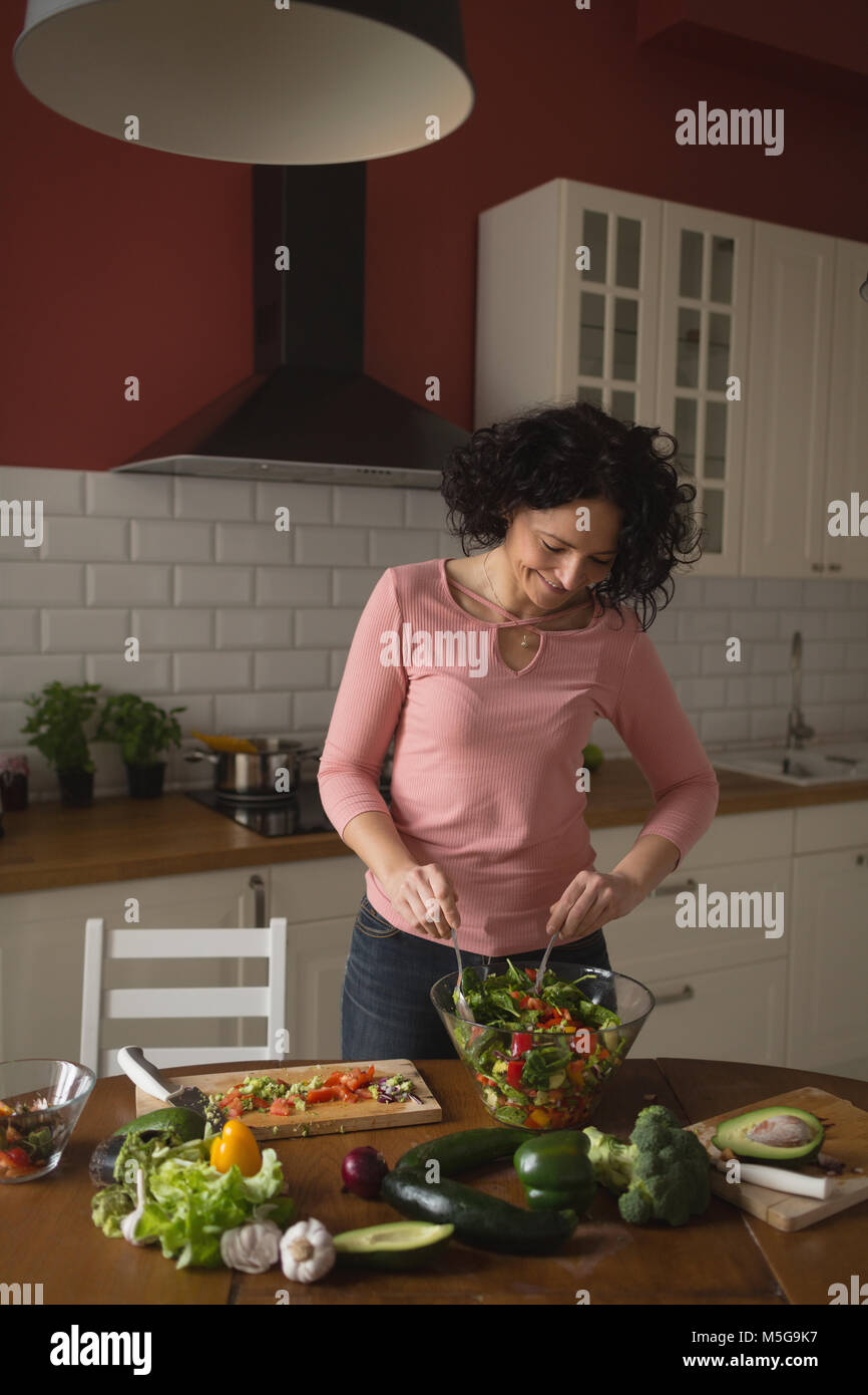 Frau Vorbereitung Gemüse Salat in der Küche Stockfoto