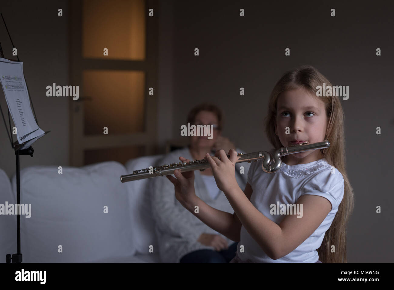 Mädchen spielen Flöte im Wohnzimmer Stockfoto