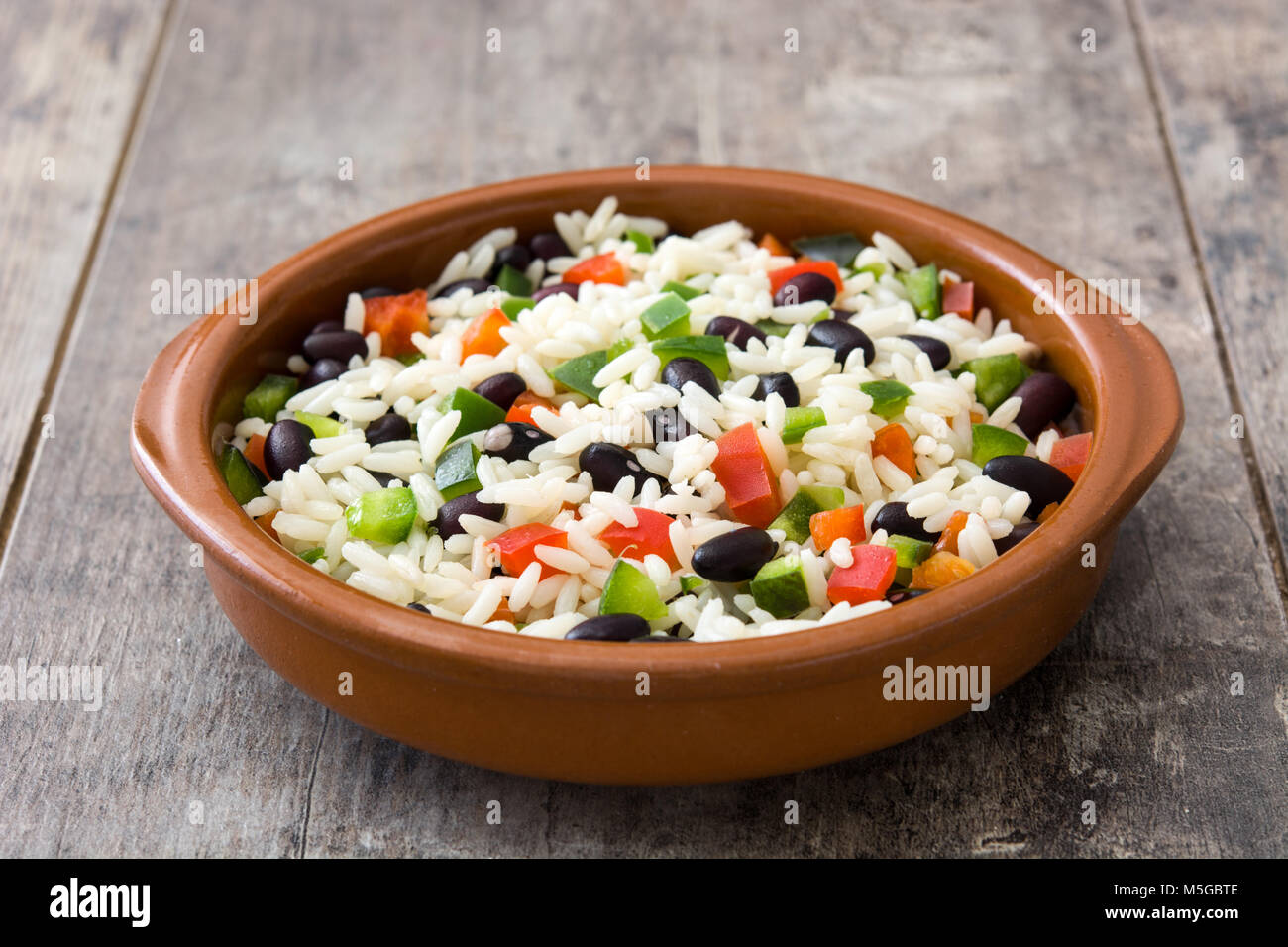 Traditionellen kubanischen Reis, schwarzen Bohnen und Paprika auf hölzernen Tisch Hintergrund. Moros y Cristianos. Stockfoto