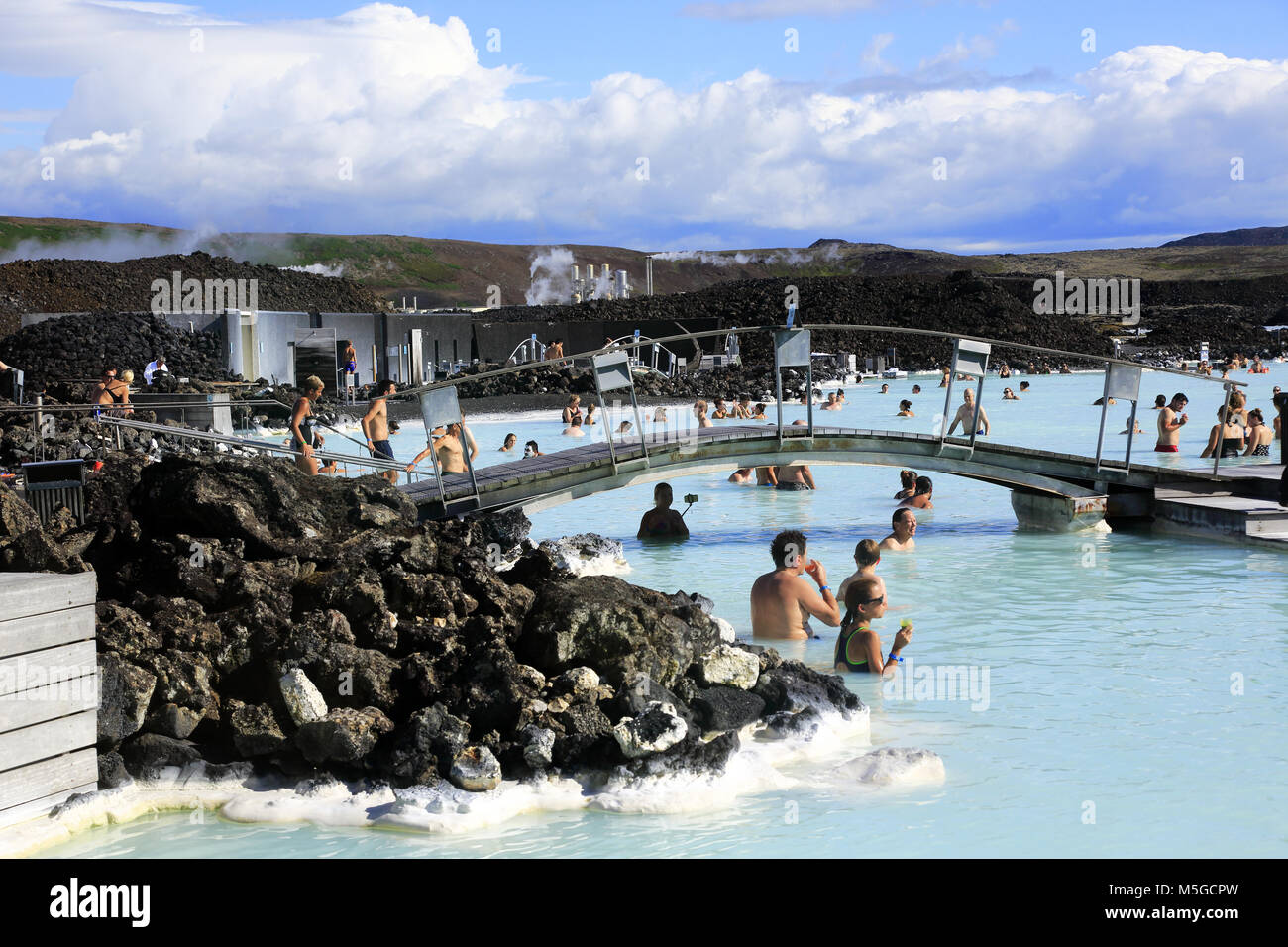 Besucher in der geothermischen Spa der Blauen Lagune mit geothermiekraftwerk Svartsengi im Hintergrund entspannen. in der Nähe von Reykjavik. Island Stockfoto