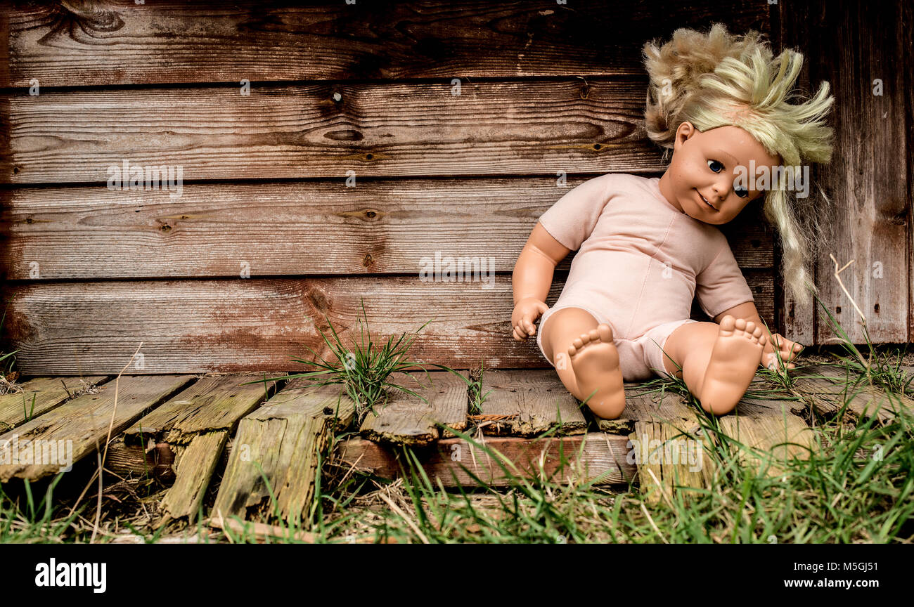 Alte vernachlässigt Puppe vor verfallenes Gebäude. Stockfoto