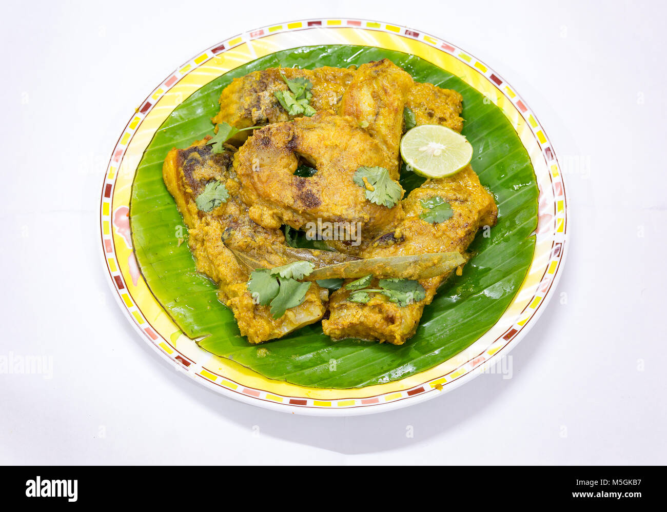 Lecker Fisch essen von Bengali Indian masala Rohu Fisch Curry im Bananenblatt mit Koriander und Zitronenscheibe serviert. Stockfoto