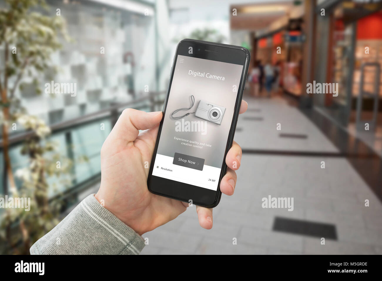 Shopping technologische Produkte mit Web site auf Smart Phone angezeigt. Shopping Mall im Hintergrund. Stockfoto