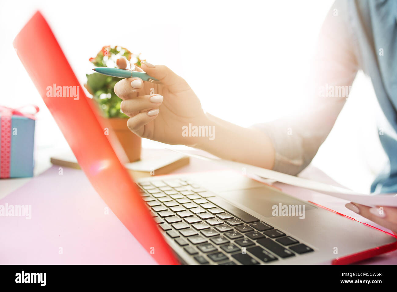 Frau Arbeiten am Computer im Büro und halten Gläser Stockfoto