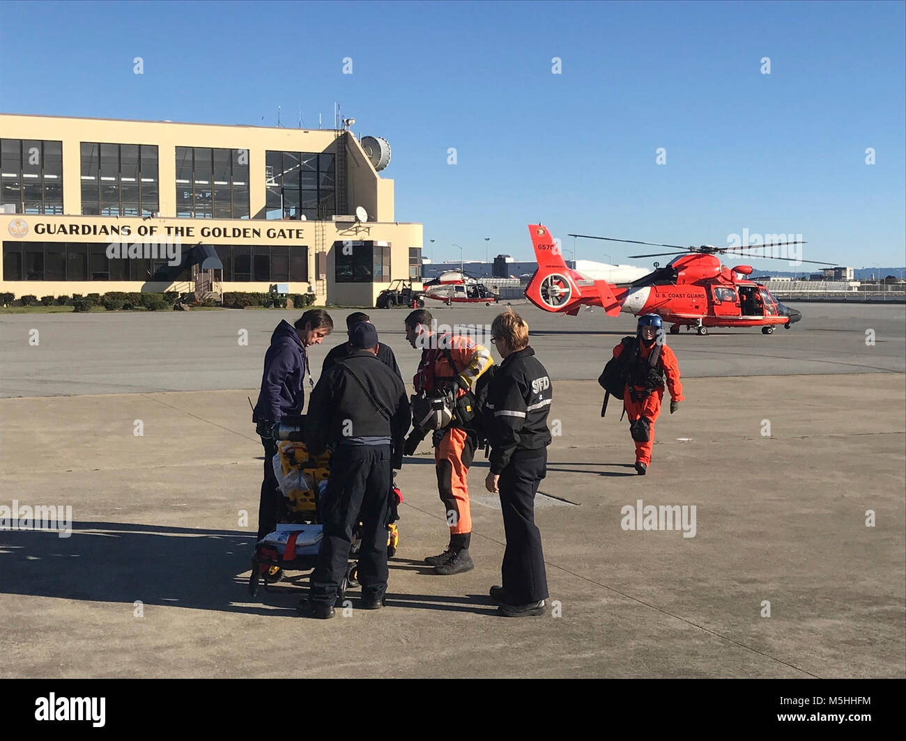 Ein Coast Guard Air Station San Francisco MH-65 Dolphin Hubschrauberbesatzung medevacs Eine 35-jährige Taiwanese Nationalen etwa 55 nautische Meilen westlich von San Francisco, 13.02.2018. Die Crew des Schiffes YM Eminenz kontaktiert Küstenwache Sektor San Francisco watchstanders Berichten, dass ein Besatzungsmitglied seine Hand verletzt und die Crew hatte Mühe, die Steuerung der Entlüftung. Lt.Cmdr. Bruce Kimmel, Lt Anders Manley, Petty Officer 1st Class Jon Kline und Petty Officer 3. Klasse Nicole Fontes waren die Mitglieder der Küstenwache aircrew. (U.S. Küstenwache Stockfoto