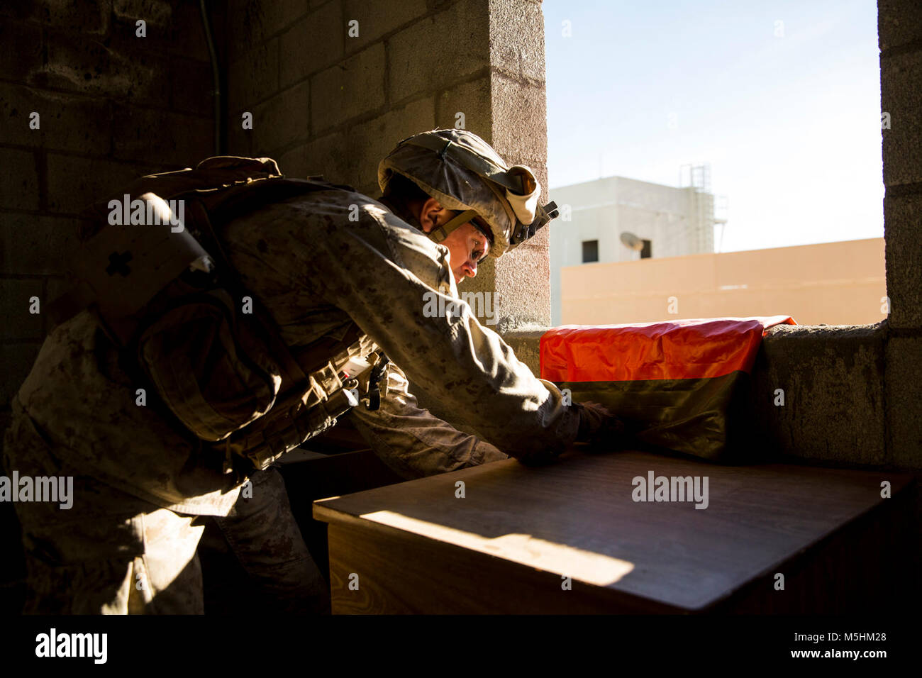 Ein Marine mit 3Rd Battalion, 7th Marine Regiment, Vorhänge mit einer Kennzeichnung Flagge aus einem Gebäude für die Opfer in Reichweite 220 an Bord der Marine Corps Air Ground Combat Center Twentynine Palms, Calif., Feb 9, 2018 zu finden im Rahmen der Integrierten Ausbildung Übung 2-18. Der Zweck von ITX ist eine anspruchsvolle, realistische Umgebung, produziert combat ready"-Kräfte, die als integrierte Magtf zu erstellen. (U.S. Marine Corps Stockfoto