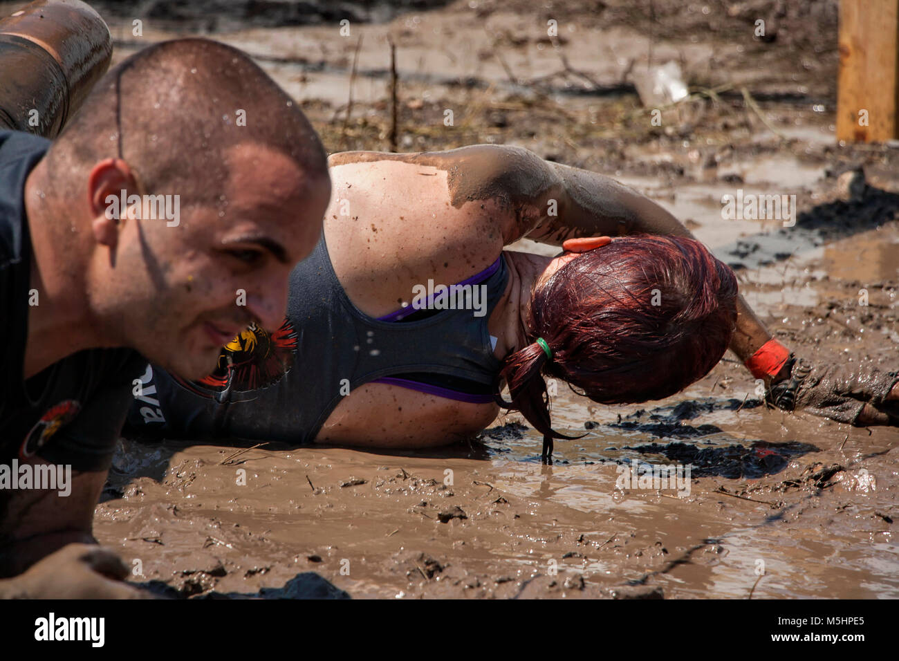 Ein Mann und eine Frau kriecht unter Stacheldraht während der Stärke rennen Legion in Sofia, Bulgarien am 26. Juli 2014 statt Stockfoto