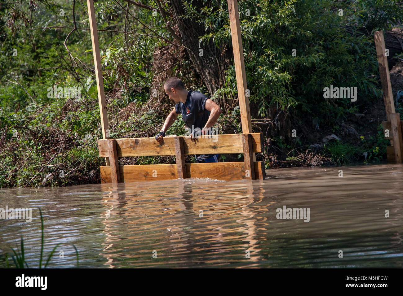 Ein Mann allein, die einen Fluß überquert, Herausforderung, die in der physischen Wettbewerb Legion in Sofia, Bulgarien am 26. Juli 2014 statt Stockfoto