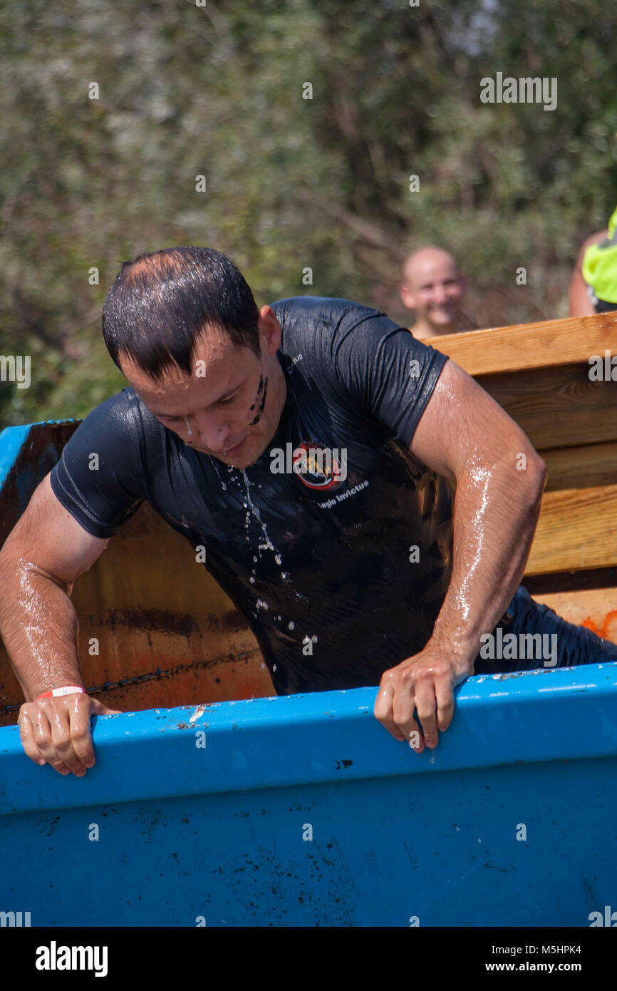 Ein Mann wird aus dem eisigen Wasser an die physische Herausforderung Wettbewerb Legion in Sofia, Bulgarien am 26. Juli 2014 statt Stockfoto