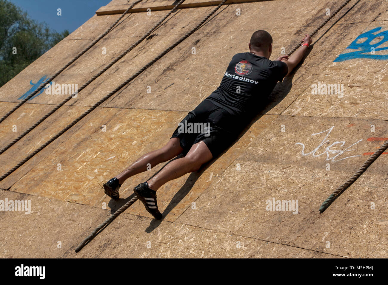 Ein Mann, der versucht, mit einem Seil auf fast senkrechten Wand zu klettern an der Stärke rennen Legion in Sofia, Bulgarien am 26. Juli 2014 statt Stockfoto