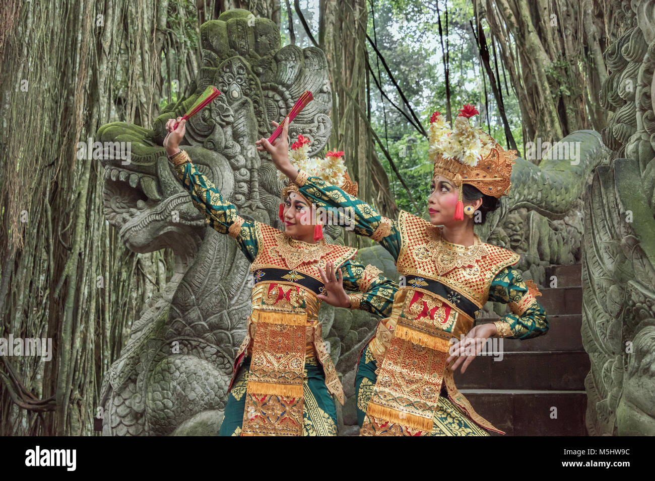 Balinesische Tänzer auf dem Drachen Brücke mit ficus Wurzeln, Heilige Affenwaldstation, Ubud, Bali Stockfoto