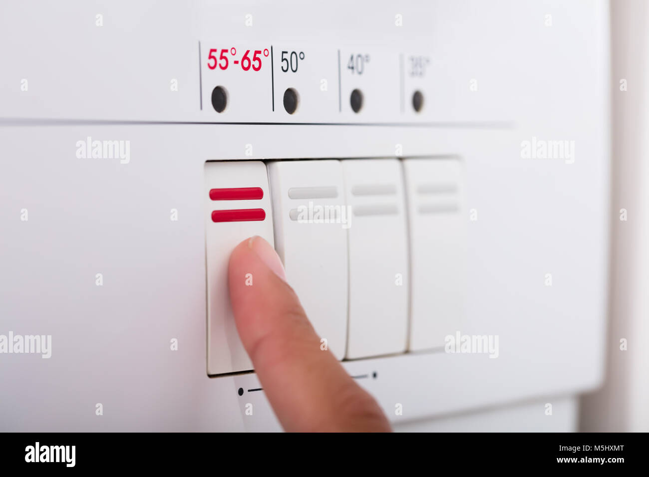 Nahaufnahme der Person Hände Drücken der Taste der Spülmaschine in der Küche Stockfoto
