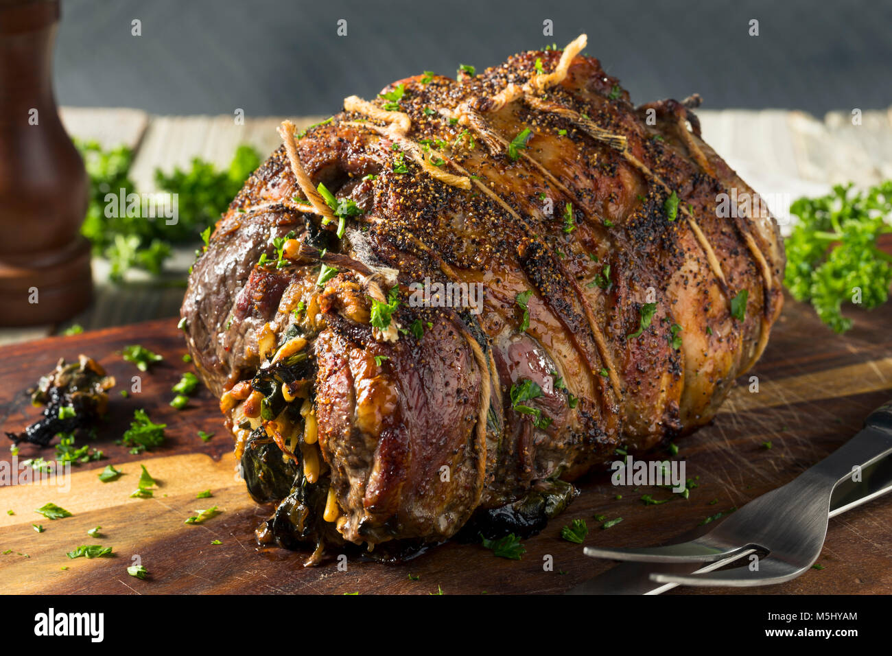 Gebratene gefüllte Lammkeule mit Spinat und Pinienkernen Stockfoto
