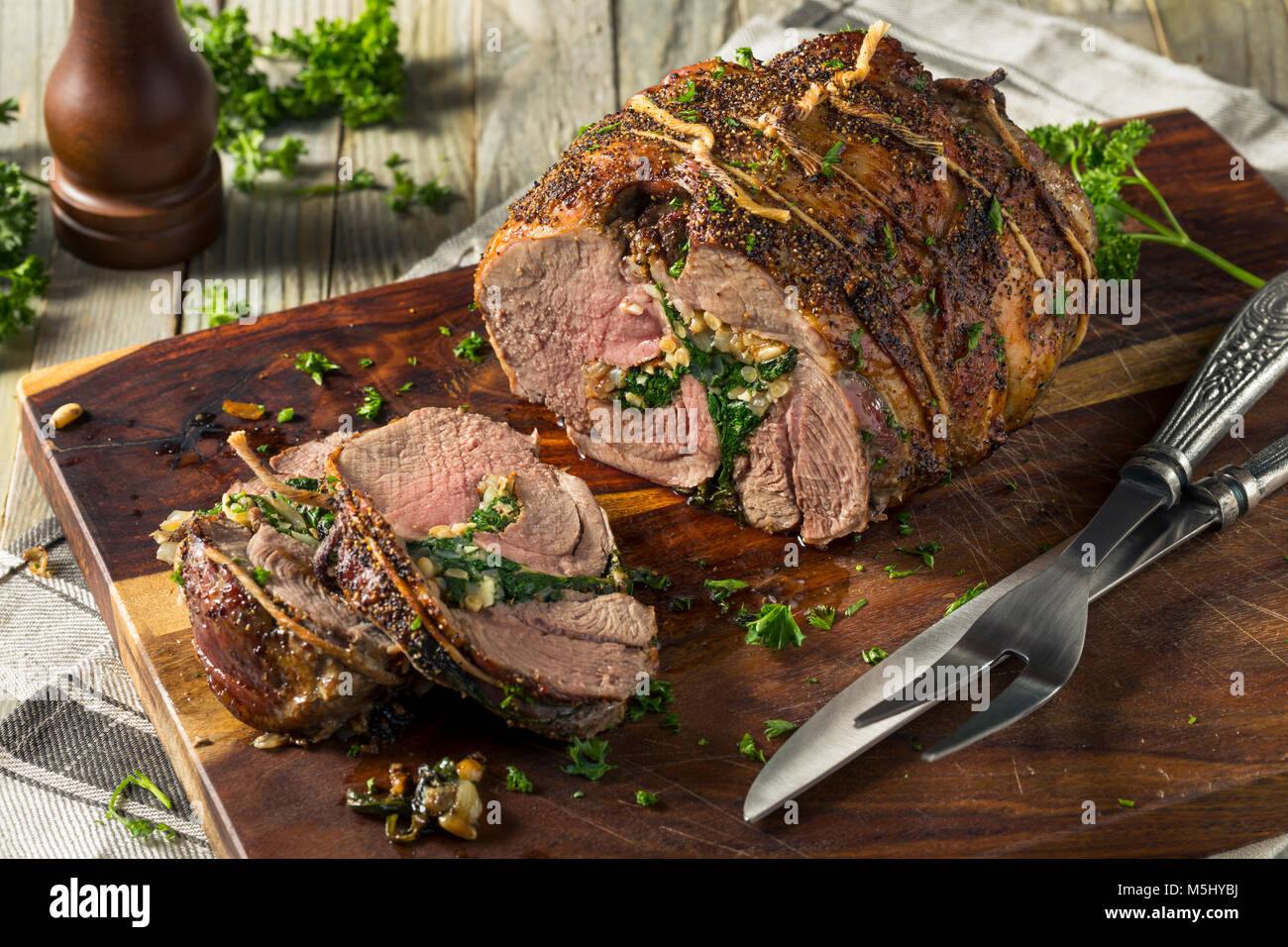 Gebratene gefüllte Lammkeule mit Spinat und Pinienkernen Stockfoto