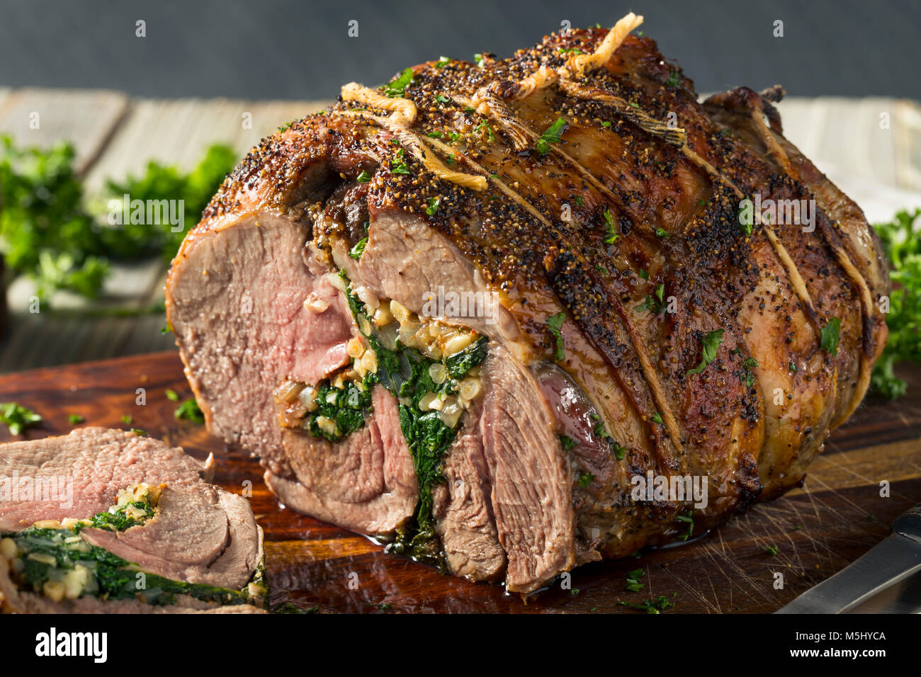 Gebratene gefüllte Lammkeule mit Spinat und Pinienkernen Stockfoto