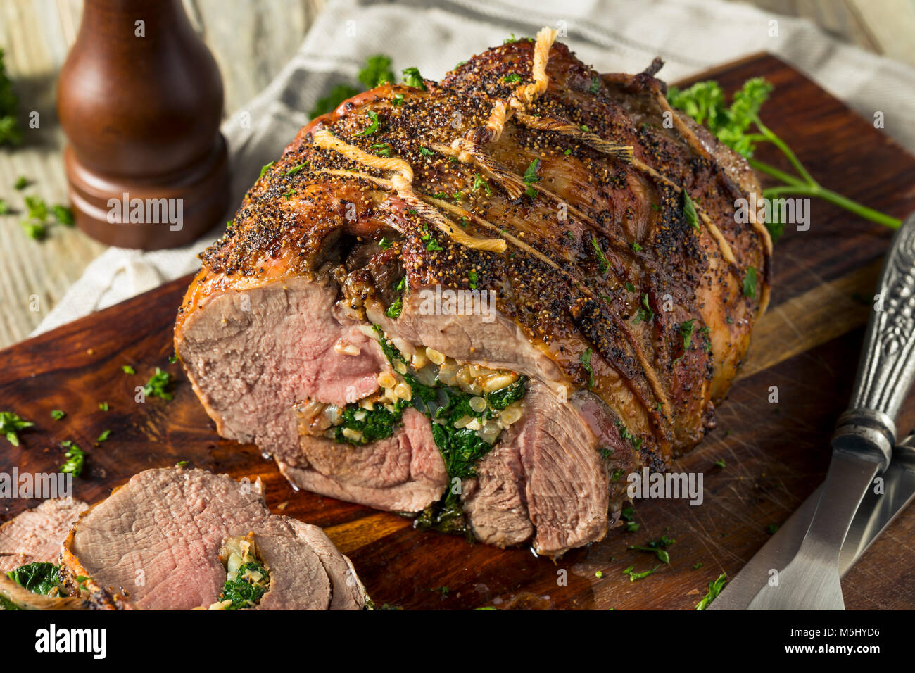 Gebratene gefüllte Lammkeule mit Spinat und Pinienkernen Stockfoto