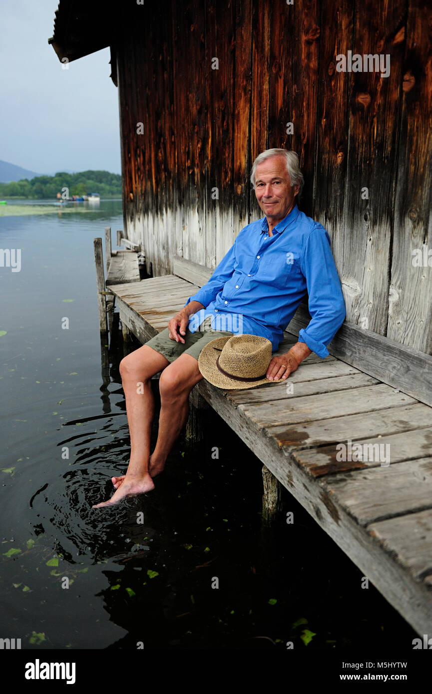 Portrait von lächelnden älteren Mann sitzt auf Steg im Sommer Stockfoto