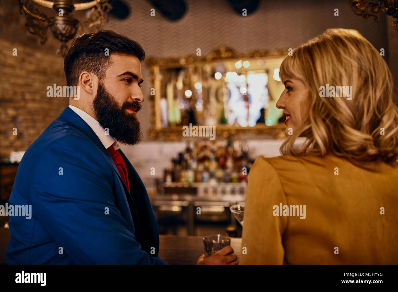 Elegantes Paar an jedem anderen lächelnd in einer Bar Stockfoto