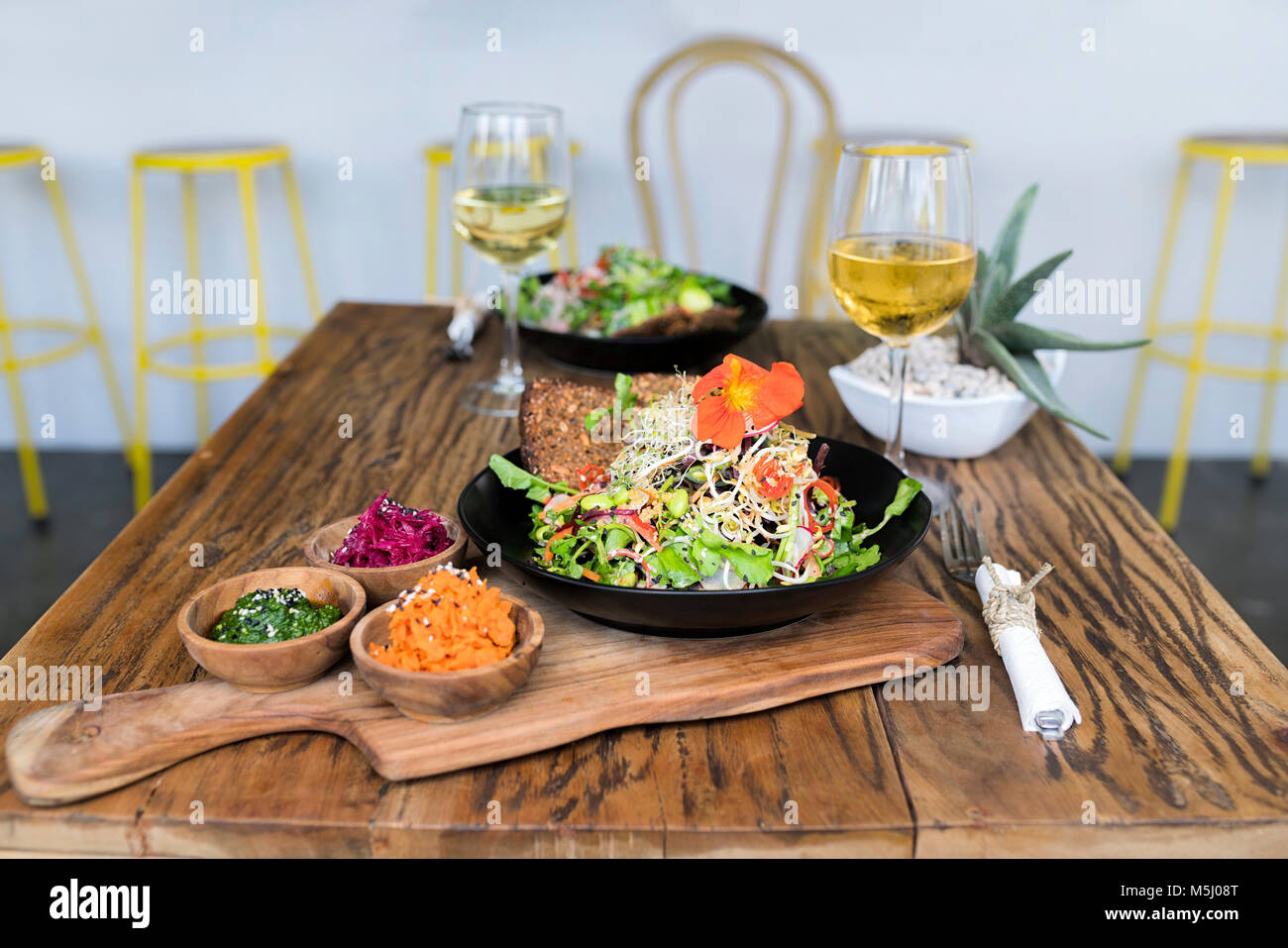 Dekoriert salat Schüsseln auf hölzernen Tisch mit Gläsern Wein Stockfoto