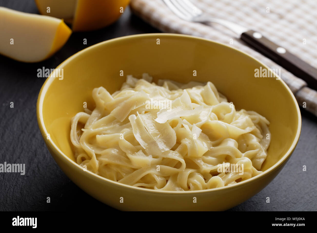 Fettuccine Alfredo mit Parmesan Käse auf einem rustikalen Tisch Stockfoto