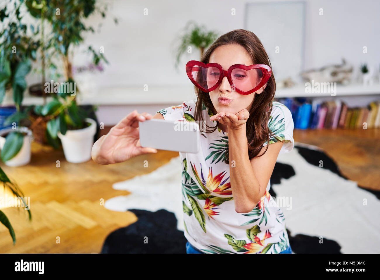 Junge Frau im Herzförmigen Gläser unter selfie Stockfoto