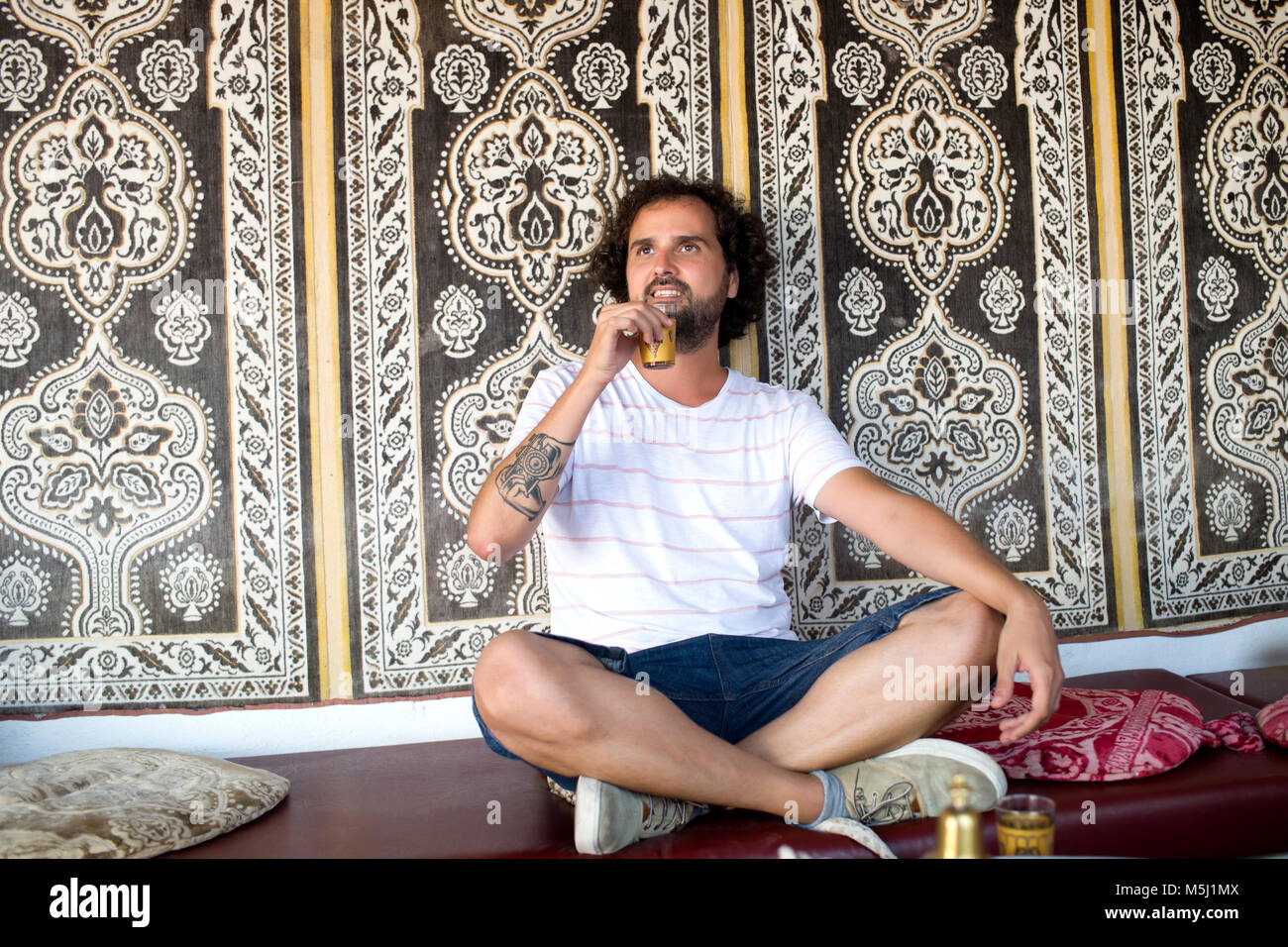 Marokko, Portrait eines Mannes mit Tattoo auf seinem Unterarm trinken Glas Tee Stockfoto