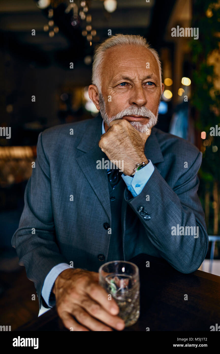 Portrait von eleganten älterer Mann in einer Bar mit Zuhaltung Stockfoto