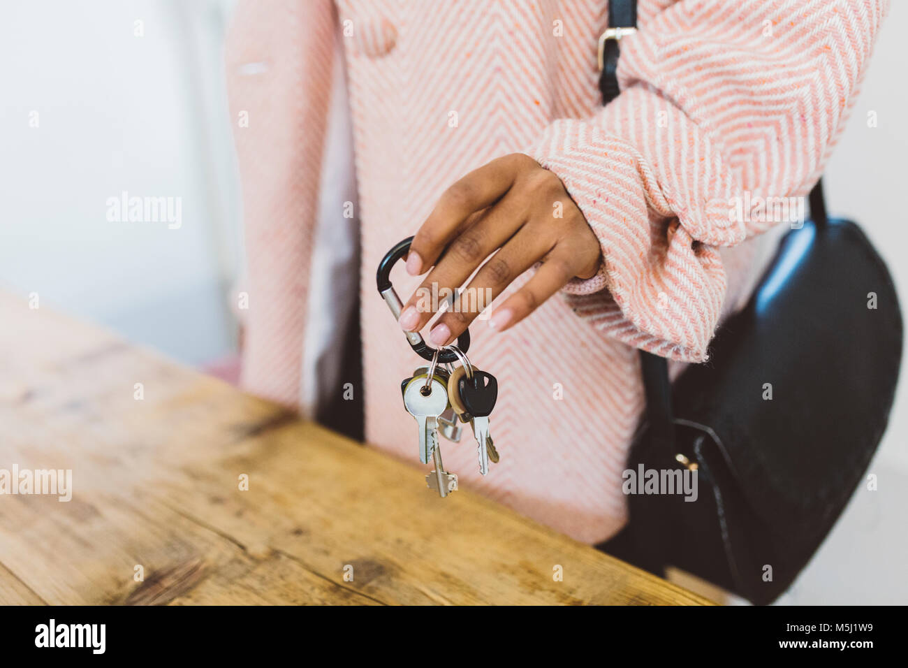 Frau nach Hause kommen, setzen Tasten auf Tabelle Stockfoto