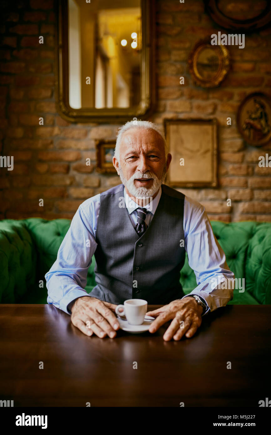 Portrait von eleganten älterer Mann sitzt am Tisch in einem Cafe Stockfoto